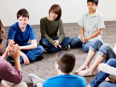 Group of young teens listening to teacher