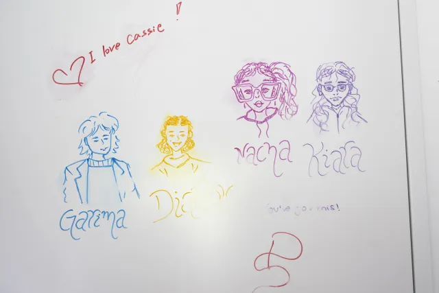 Das Bild zeigt eine Zeichnung mit vier stilisierten Köpfen, über denen die Namen Kiara, Nacha, Garima und Diariou stehen. Die Zeichnung befindet sich auf der Zimmertür der vier Mädchen. 