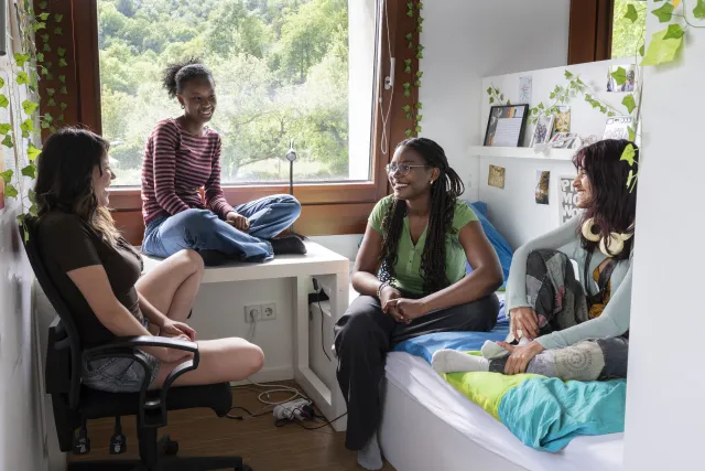 Garima, Diariou, Kiara und Nacha sitzen in ihrem Zimmer im UWC  
