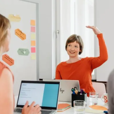 Mitarbeiterinnen der Robert Bosch Stiftung im Gespräch. Im Hintergrund ist ein Flip Chart mit Post its zu sehen.  